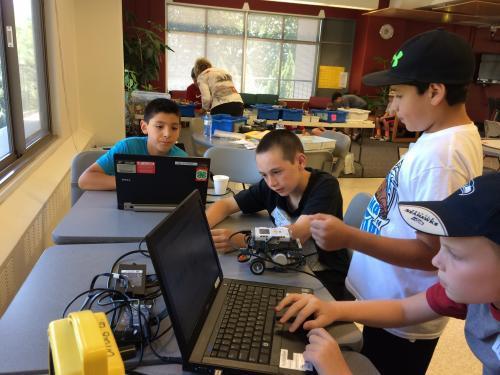 kids working on computers and robots