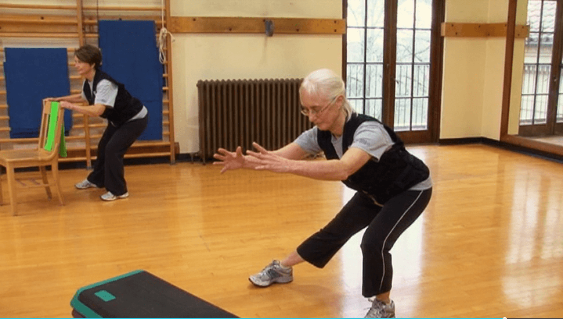 2 women lunging to the side in a gym
