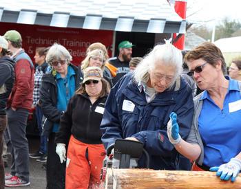 Jean Azlein (left) of McMinnville makes practice cuts under the guidance of instructor Alison Henynderickx in the Women and Chainsaw Safety course at the 2019 Clackamas Tree School.