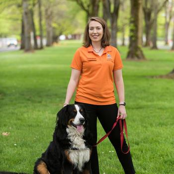 Dr. Kristen Moore standing next to her Bernese Mountain Dog, Beau.
