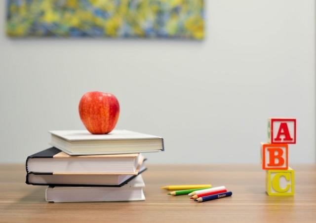 School supplies, books, apple on a desk