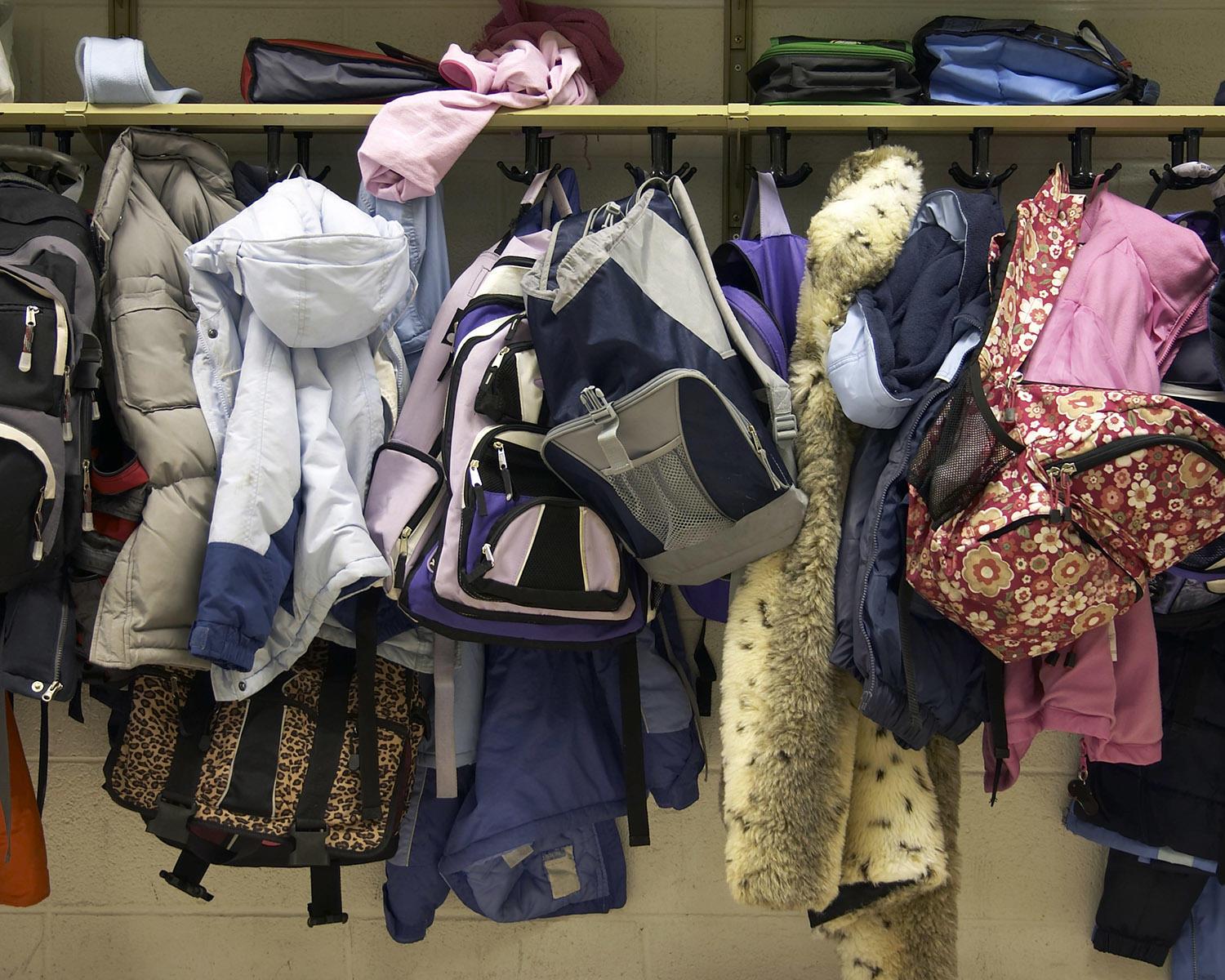 backpacks and coats in cluster on rack