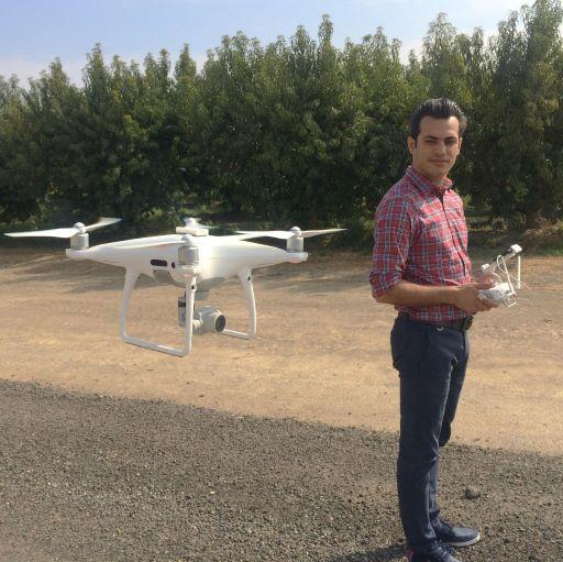 Dr. Alireza Pourreza operates a drone in a California orchard.