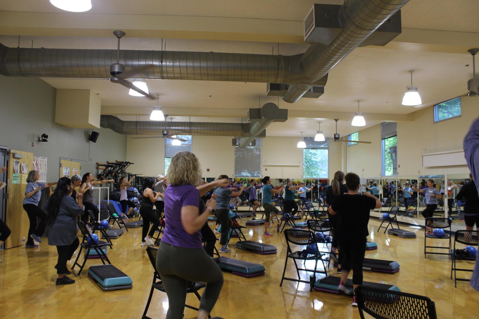 Gym full of individuals participating in an exercise class