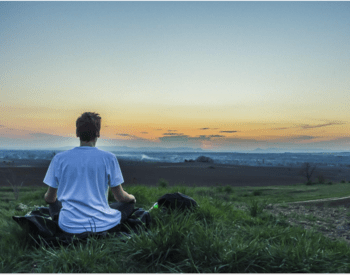 person sitting in an outdoor space at sunset