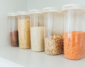Airtight plastic containers of rice, oats, and other dried goods.
