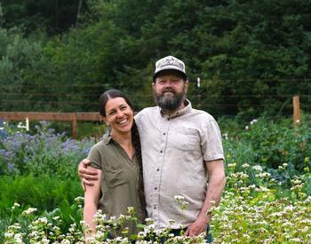 Julie Hackett & John Hall of Laughing Rabbit Farm in a field