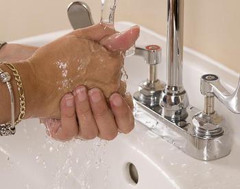 Washing soap off hands at a sink - photo by Amanda Mills and from CDC