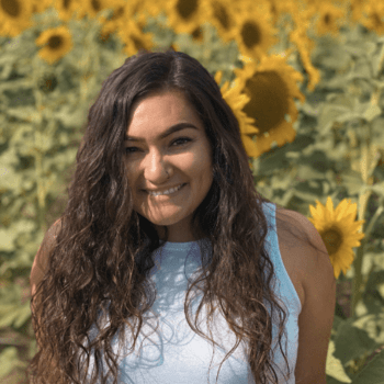 Portrait photo of Nayeli Contreras with field of sunflowers in the background