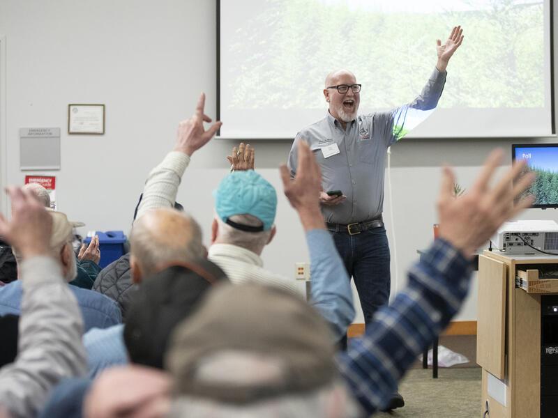 Dan Stark asks for a raise of hands at an indoor tree workshop