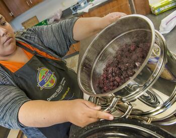 Woman pulling steam juicer off of stove top