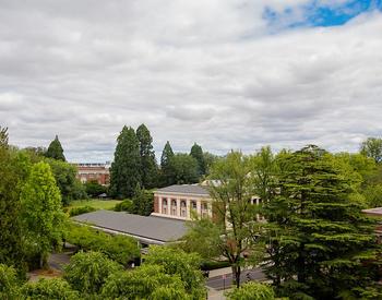 ChatGPT said:  A view of a lush, green campus with trees and several buildings under a partly cloudy sky.