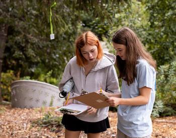 Two teenagers attending YOCLS workshop on tree identification.