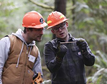 Tree School instructor shows student a tree core